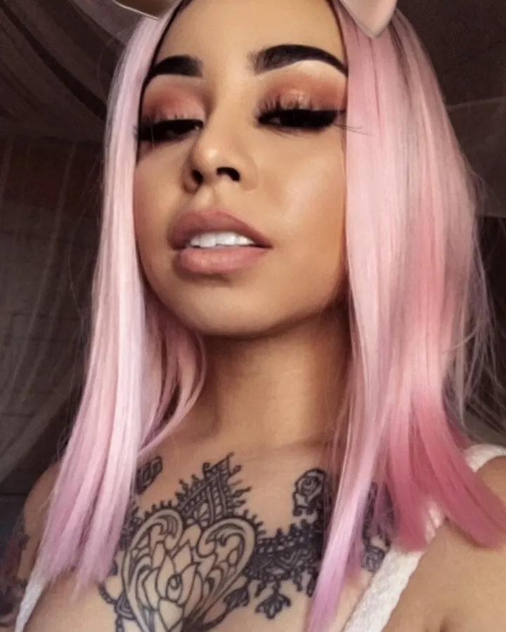 Amandine en perruque rose, nœud sur la tête, tatouages